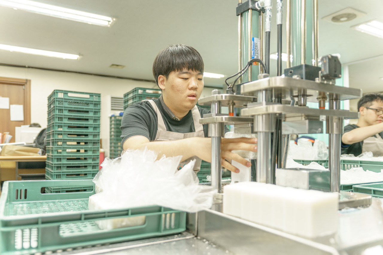 A worker at Donggubat makes premium organic soaps at the company’s factory in Seongdong-gu, Seoul. (Donggubat)