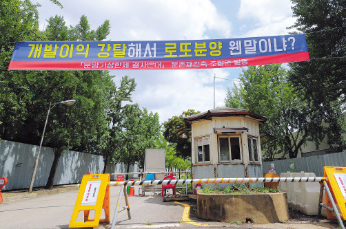 지난 16일 서울 강동구 둔촌주공 아파트 철거현장 입구에서 주민들이 플래카드를 걸어 정부의 분양가상한제 도입을 항의하고 있다. [연합]