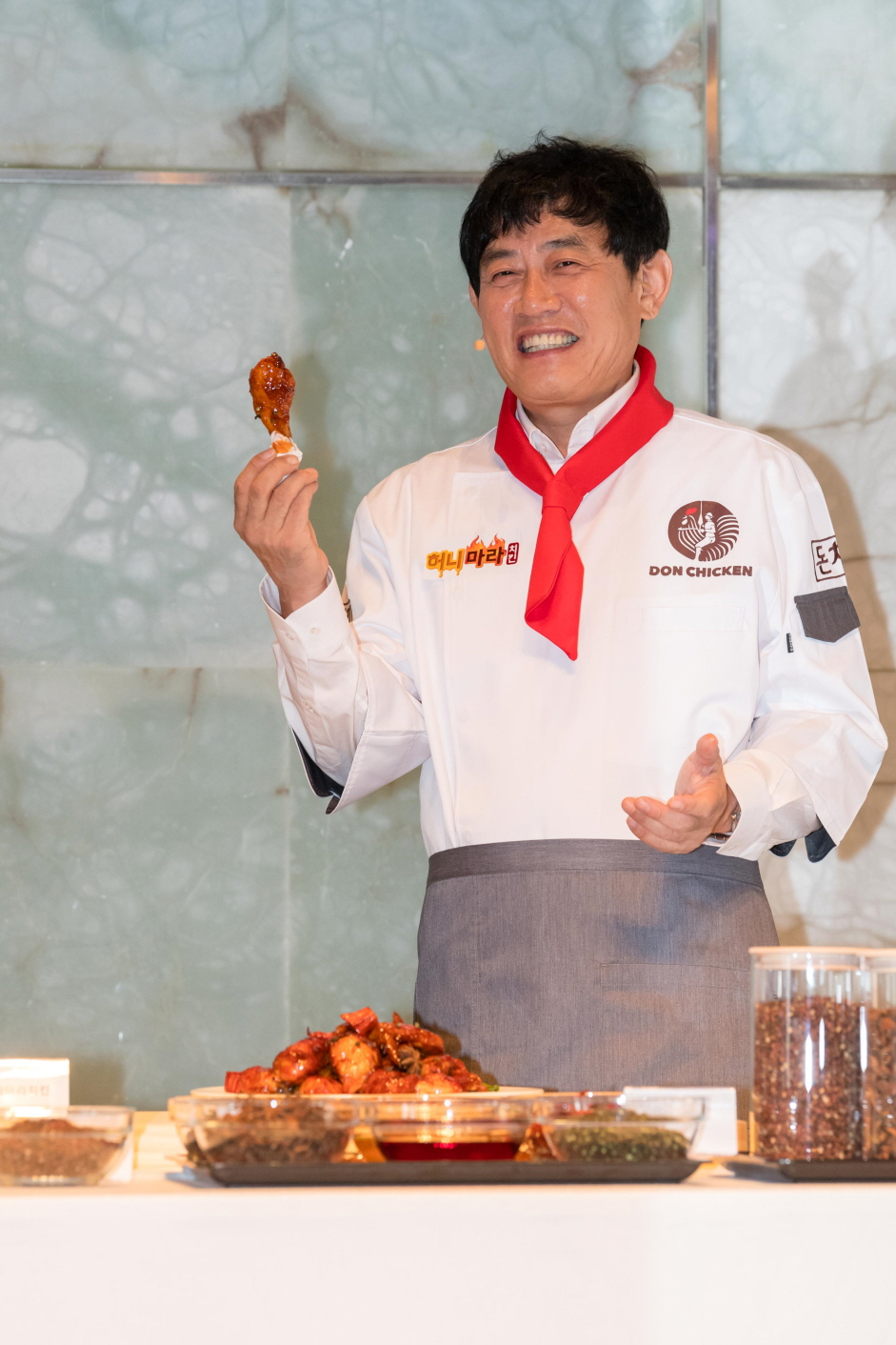 방송인 이경규가 20일 서울 중구 더 플라자 호텔 다이아몬드 홀에서 열린 기자간담회에서 직접 개발한 돈치킨 신제품 '허니마라치킨(이경규 치킨)'을 선보이고 있다. [돈치킨 제공]