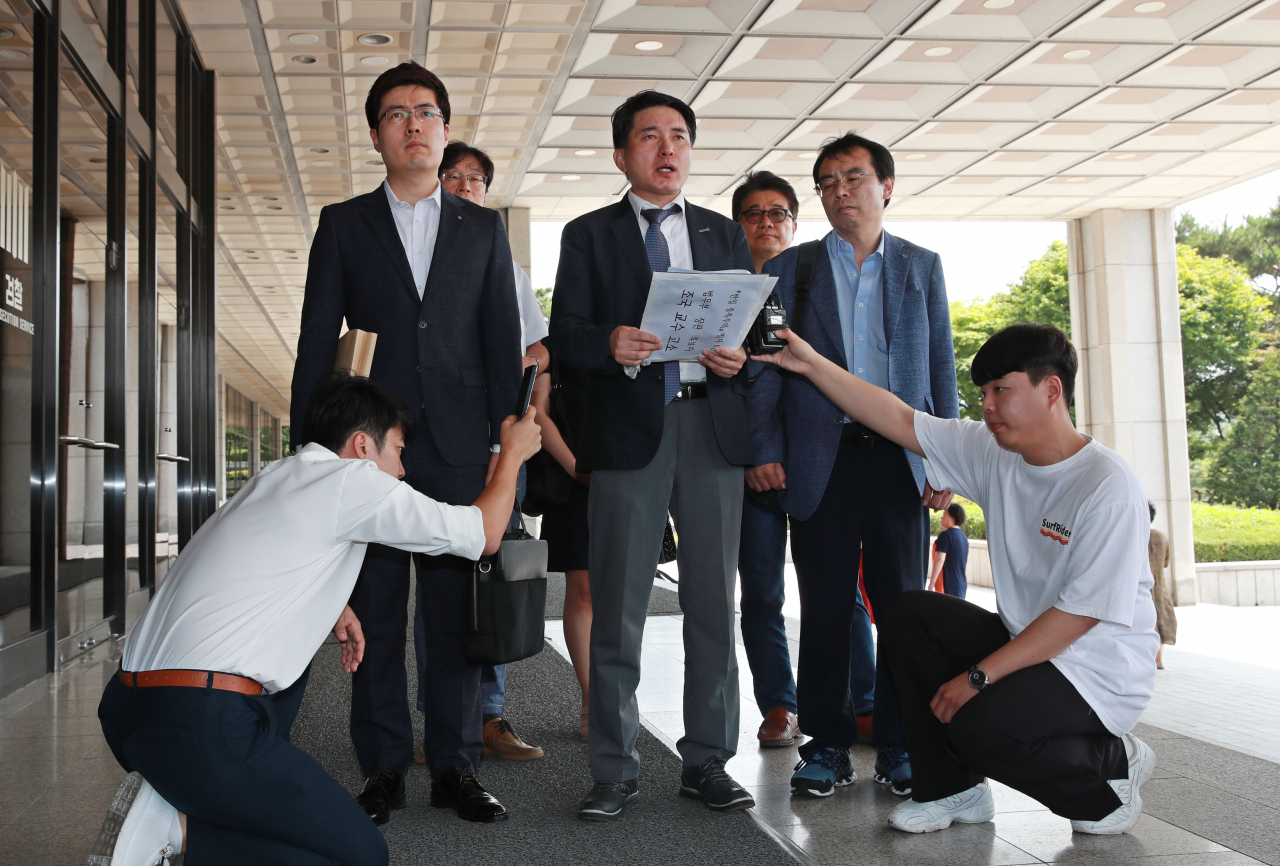 주익종 낙성대경제연구소 연구위원(가운데)이 조국 법무부 장관 후보자를 모욕죄로 고소하기 위해 20일 오전 서울중앙지검에 들어서며 성명서를 읽고 있다. [연합]