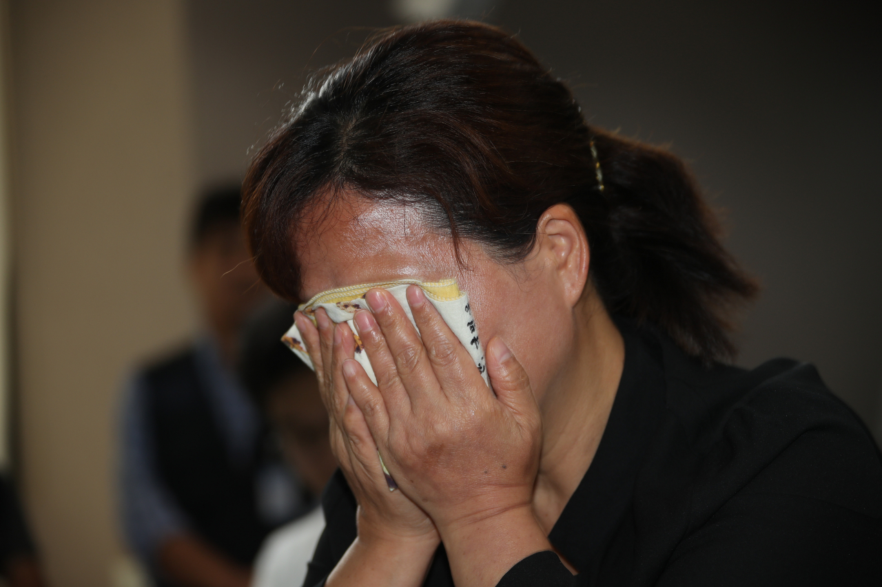 19일 정부서울청사에서 열린 ‘고 김용균 사망사고 진상규명과 재발방지를 위한 석탄화력발전소 특별노동안전조사위원회의 진상조사’ 결과 보고장에 어머니 김미숙 씨가 눈물을 흘리며 발표를 듣고 있다. [연합]