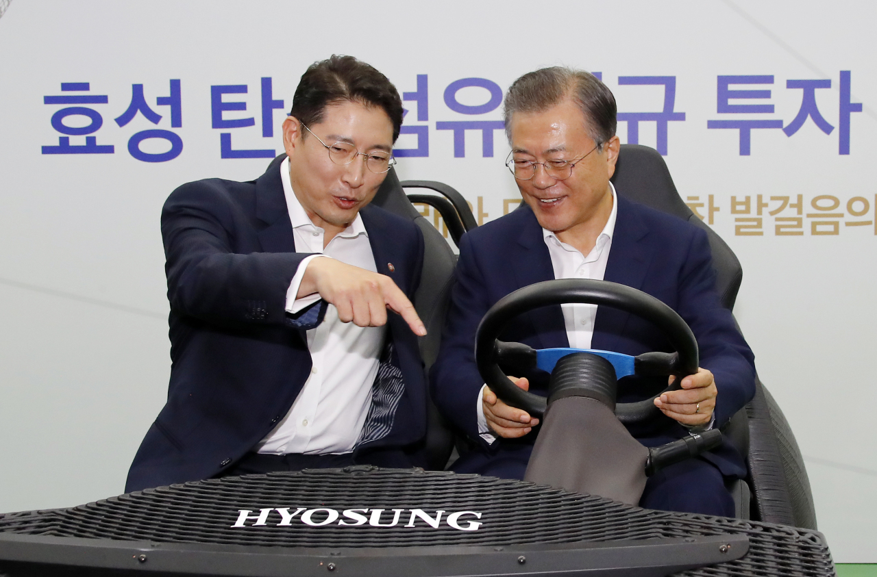 President Moon Jae-in and Hyosung Chairman Cho Hyun-joon take a 3D printed carbon fiber electric vehicle at Hyosung's Jeonju plant on Tuesday. (Yonhap)
