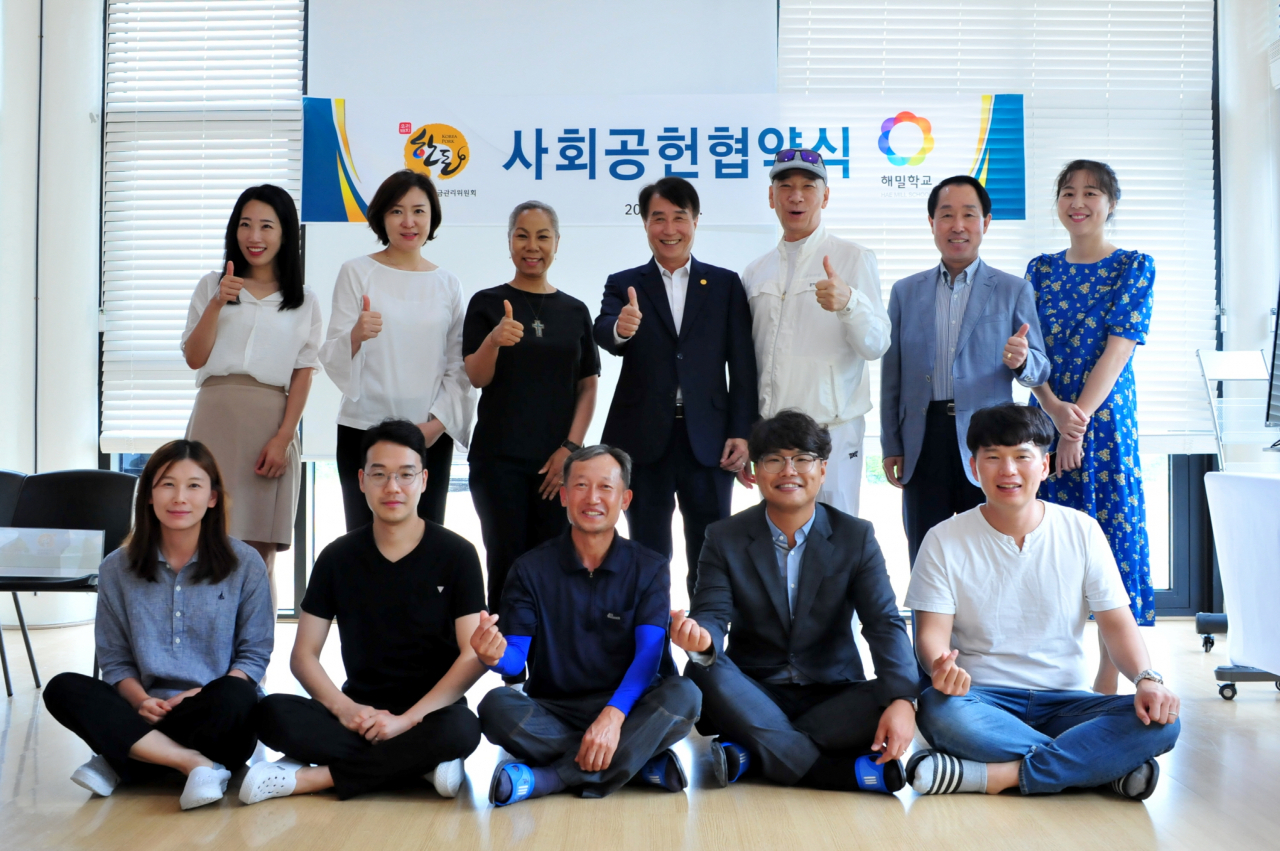 하태식 한돈자조금위원장(뒷줄 오른쪽에서 네번째)과 가수 인순이(김인순) 해밀학교 이사장(뒷줄 왼쪽에서 세번째)이 사회공헌 업무협약을 체결 한 뒤 해밀학교 교직원들과 기념촬영을 하고 있다. [한돈자조금위원회 제공]