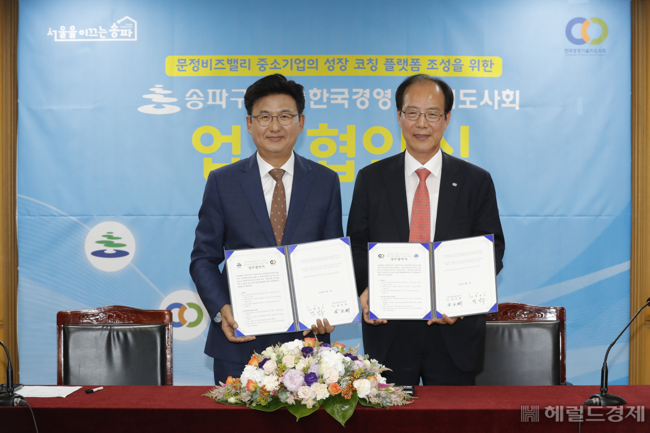 박성수(왼쪽) 송파구청장이 지난 6월에 열린 경영기술지도사회 협약식에서 협약을 체결한뒤 기념촬영을 하고 있다.[송파구]