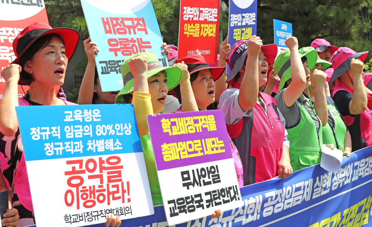 전국학교비정규직연대회의 관계자들이 22일 서울 종로구 서울시교육청 앞에서 정부와 교육당국에 직접 교섭 촉구 기자회견을 열고 학교 비정규직 정규직화와 공정임금제 실현을 촉구하는 구호를 외치고 있다. [연합]