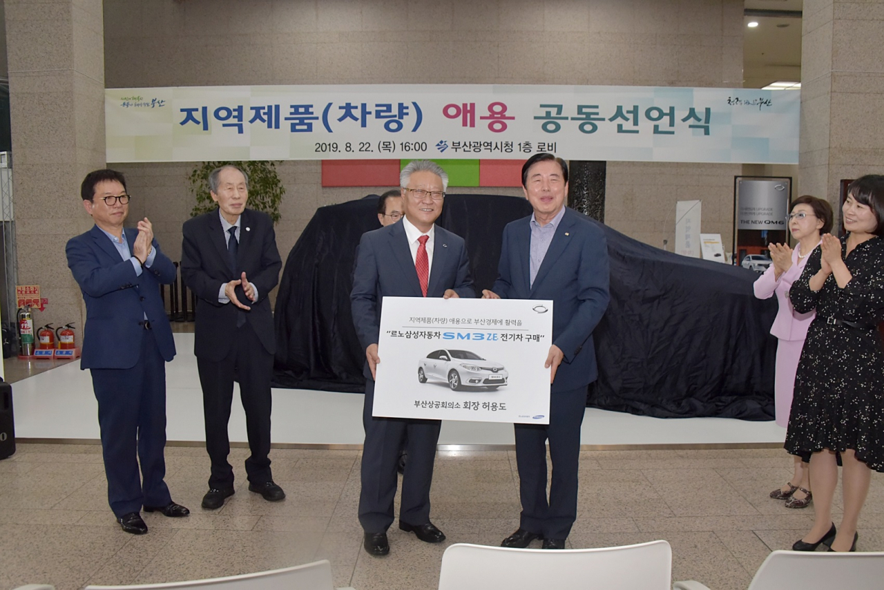 르노삼성자동차 심영택 지역본부장(왼쪽)이 허용도 부산상공회의소장에게 SM3 Z.E.를 인도하고 있다. [르노삼성차 제공]
