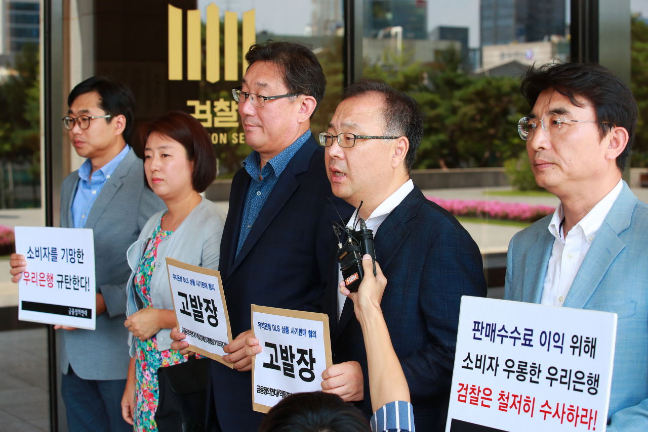 금융정의연대, 약탈경제반대행동, 키코공동대책위원회 등 경제시민사회단체 회원들이 23일 오후 서울 서초구 서울중앙지검 앞에서 금리연계 파생결합증권(DLS) 사기 판매 혐의로 우리은행을 고발하는 고발장을 접수하기 앞서 입장을 밝히고 있다. 연합뉴스