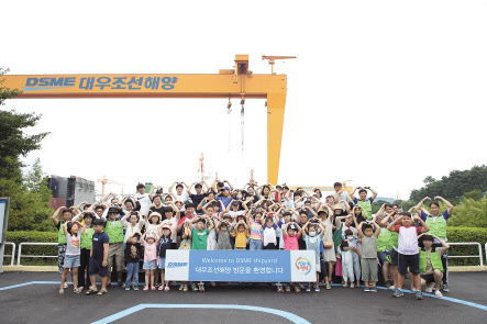대우조선해양 새싹의 소리회 봉사단이 지난 25일 거행된 ‘새생명 바다축제’ 행사에서 백혈병 소아암 환아 및 가족들을 초청해 대우조선해양을 견학하고 기념촬영을 하고 있다. [대우조선해양 제공]