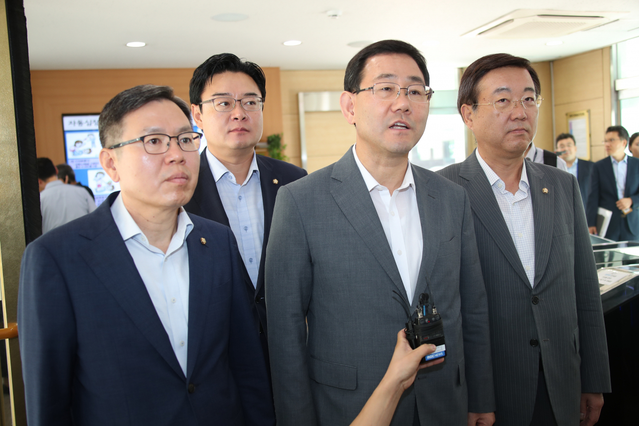 주호영 의원(왼쪽 세 번째) 등 국회 정무위원회 소속 자유한국당 의원들이 26일 오전 금융위원회 민원실을 직접 방문해 조국 법무부 장관 후보자의 배우자와 자녀들이 투자한 사모펀드 '블루코어밸류업1호'에 대한 조사를 공식 요구하는 조사요구서를 제출하며 입장을 밝히고 있다. [연합]