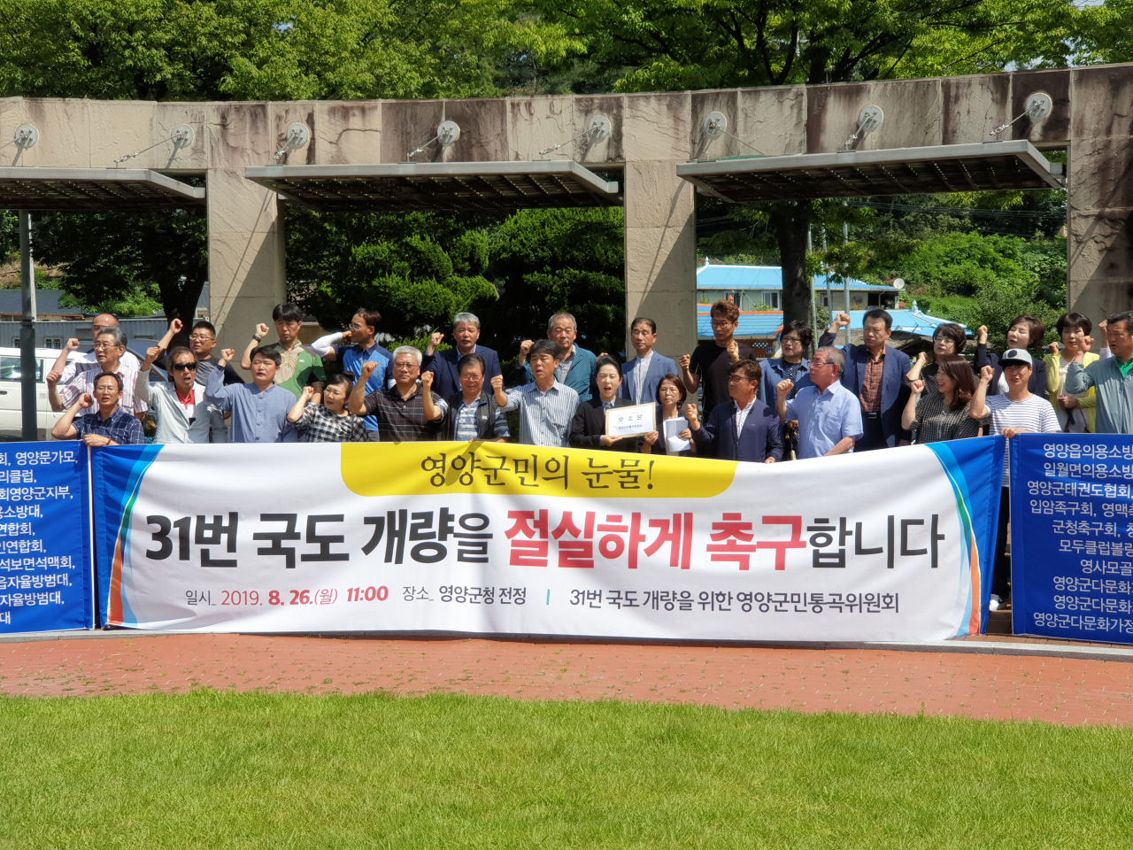 경북 영양군민들이 26일 영양군청 앞에서 국도 31호선 영양~청송 16㎞ 구간 4차선 확장을 요구하는 기자회견을 열고 있다.[사진=김병진기자]