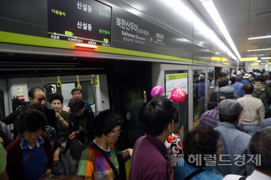 우이신설선 전동차에서 사람들이 내리고 있다.