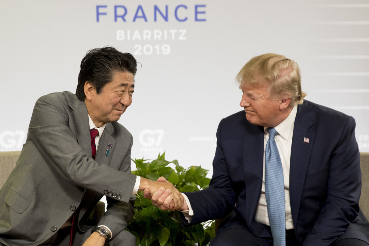 US President Donald Trump, right, shakes hands with Japanese Prime Minister Shinzo Abe for their bilateral talks during the G7 summit in Biarritz, France, 25 August 2019. The G7 Summit runs from 24 to 26 August in Biarritz. (AP-Yonhap)