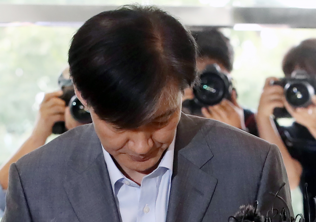 조국 법무부 장관 후보자가 27일 오후 인사청문회 준비 사무실이 마련된 서울 종로구 한 건물로 출근하고 있다. 검찰은 이날 오전 조 후보자 가족을 둘러싼 의혹과 관련해 고려대, 서울대, 부산대, 단국대 등 대학과 가족이 투자한 펀드를 운용하는 코링크PE 사무실, 가족이 운영해온 학교법인 웅동학원 등을 전격 압수수색 했다. 연합뉴스