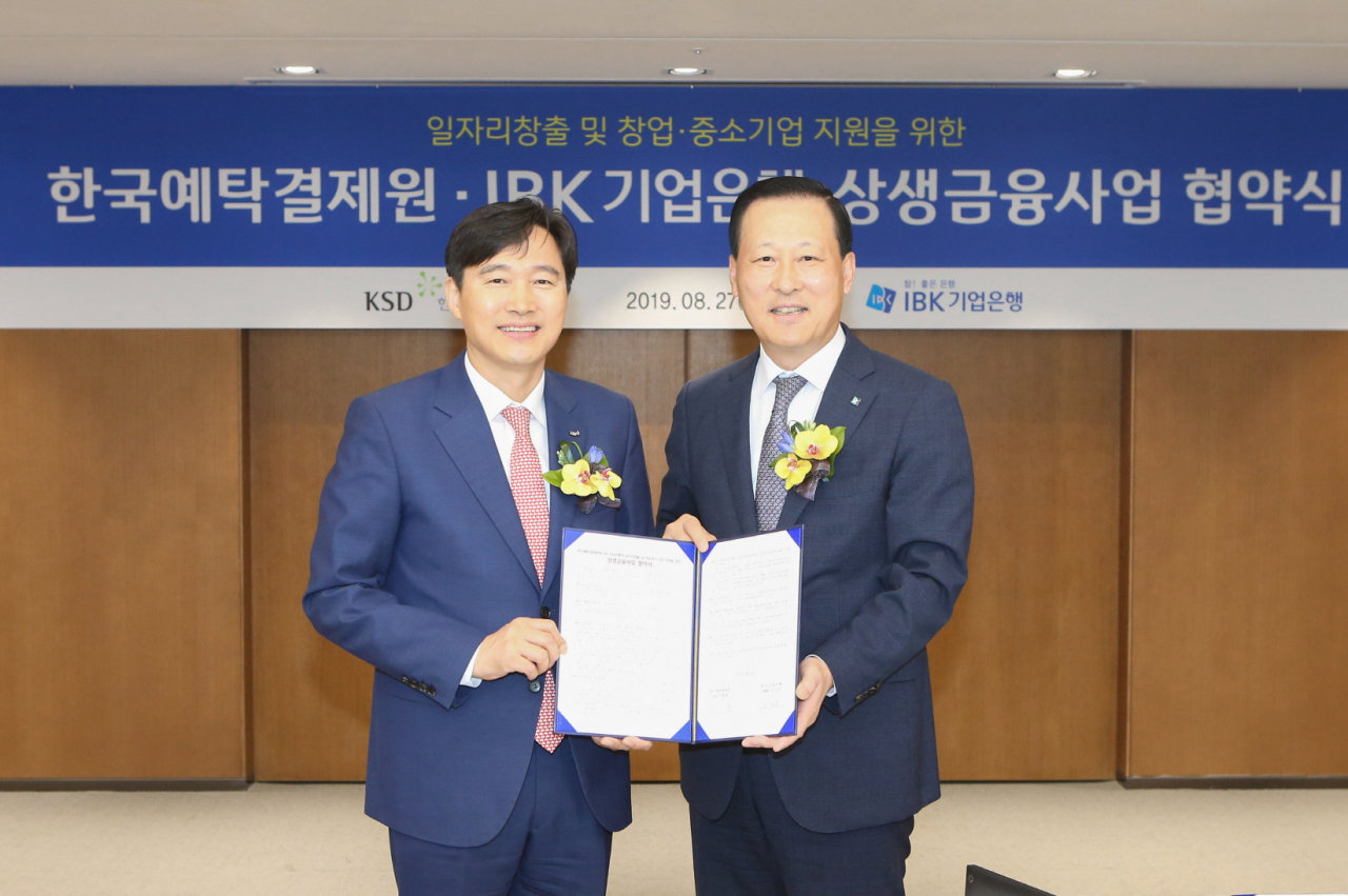 이병래 한국예탁결제원 사장(왼쪽)과 김도진 IBK기업은행장이 지난 27일 기업은행 본점에서 상생금융사업 협약 체결 후 기념촬영을 하고 있다. [한국예탁결제원 제공]