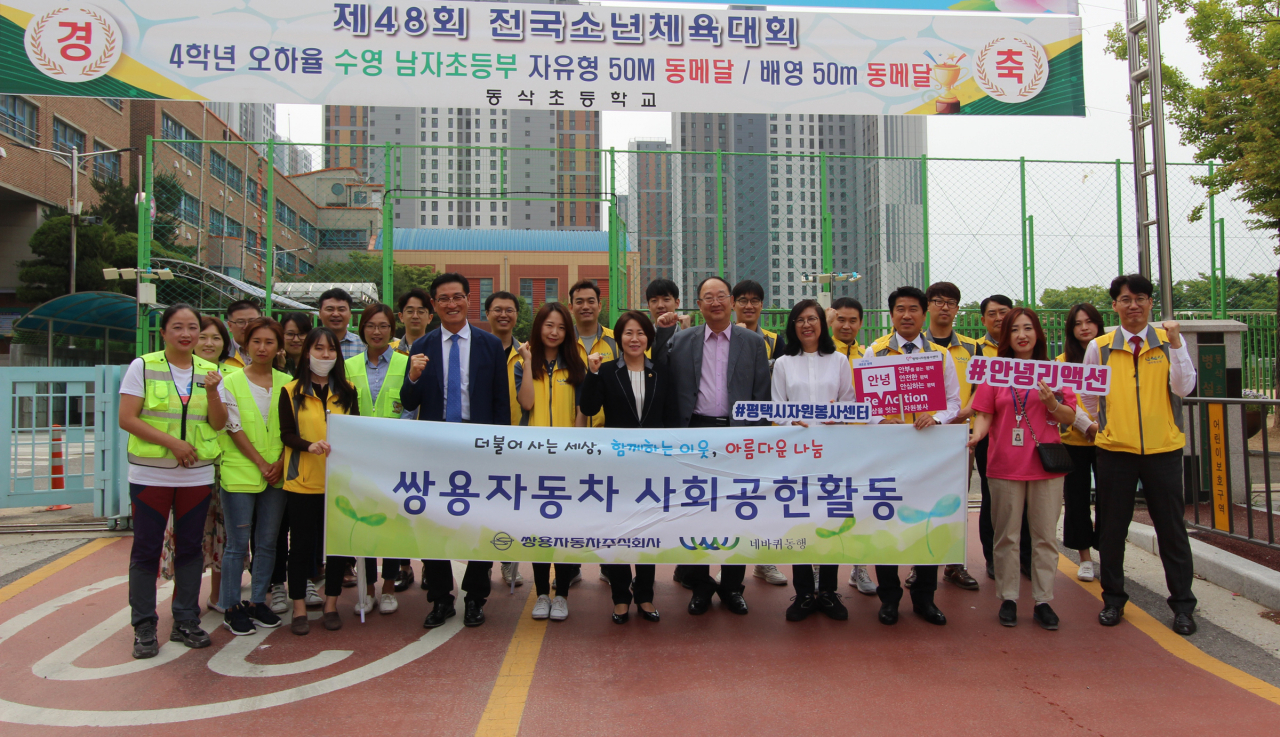 지난 6월 19일 평택 동삭초등학교에서 어린이 교통안전 캠페인에 참여한 쌍용자동차 임직원들이 기념촬영을 하고 있다. [쌍용차 제공]