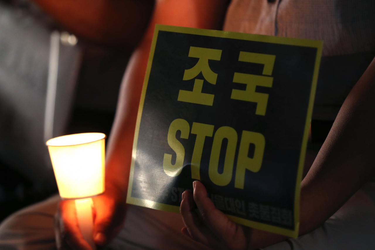 28일 오후 서울 관악구 서울대학교에서 총학생회 주최로 열린 '제2차 조국 교수 STOP! 서울대인 촛불집회'에서 한 학생이 조국 법무부 장관 후보자의 사퇴를 촉구하는 손팻말을 들고 있다. [연합]