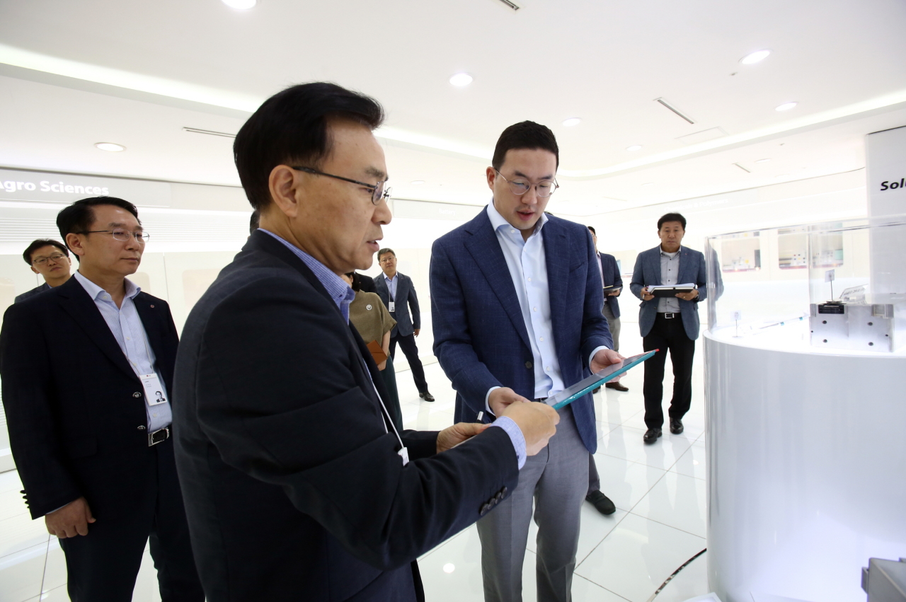 LG Chairman Koo Kwang-mo (right) looks at the third-generation battery pack developed by LG Chem for long-range electric vehicles, at the battery maker’s R&D unit in Daejeon on Thursday. With the new battery pack, electric vehicles are capable of running more than 500 kilometers on a single charge. (LG Group)