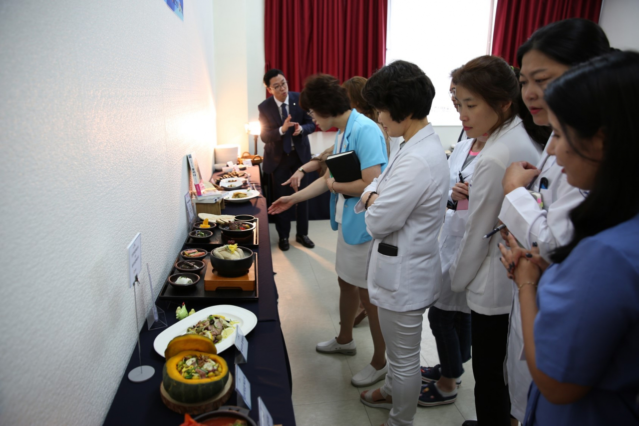 지난 30일 부평힘찬병원에서 열린 중앙아시아 진출 병원 식사 메뉴 품평회에서 힘찬병원 관계자들이 품평메뉴를 보고 있다. [아워홈 제공]