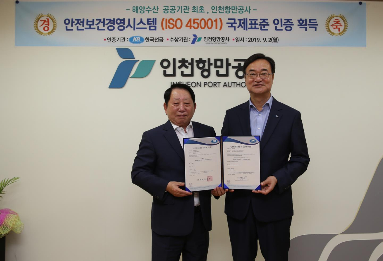 인천항만공사 남봉현〈오른쪽〉 사장과 한국선급 이정기 회장이 안전보건경영시스템 국제표준 인증패를 들고 기념사진을 촬영하고 있다.