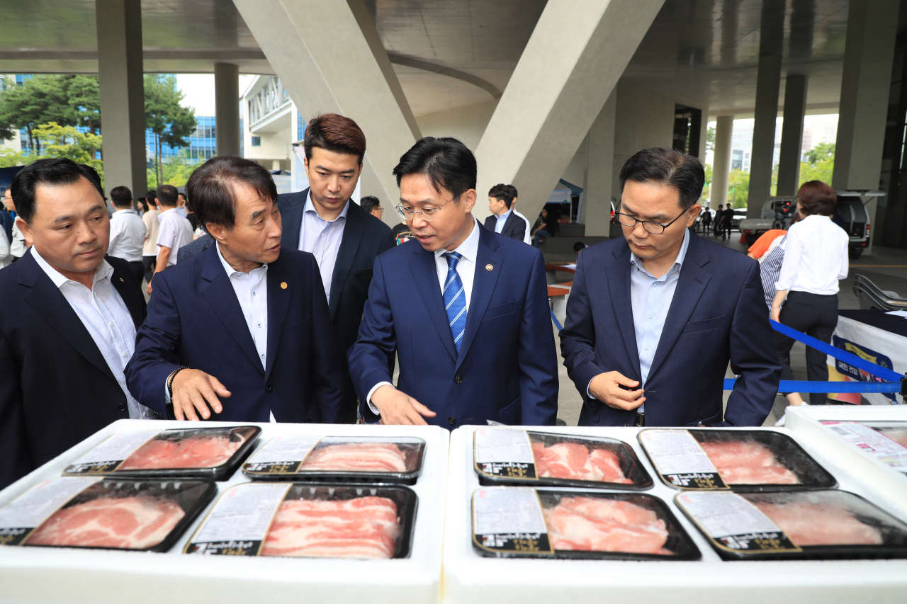 이재욱 농림축산식품부 차관(오른쪽에서 두번째)이 하태식 한돈자조금관리위원장(왼쪽에서 두번째)의 안내를 받아 정부세종청사에 열린 추석맞이 한돈판촉행사에서 돼지고기 가격과 품질 등을 살펴보고 있다. [농림축산식품부 제공]