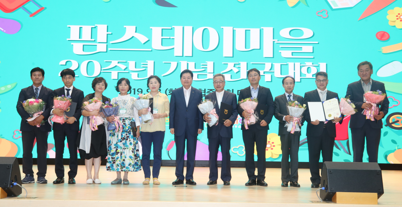 김병원 농협중앙회장(가운데)과 팜스테이마을 20주년 기념 전국대회 표창을 받은 팜스테이마을대표들이 함께 단체 기념촬영을 하고 있다. [농협 제공]