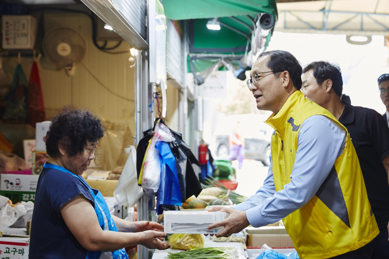 조성완 전기안전공사 사장과 임직원들이 군산 신영시장 상인에게 멀티콘센트를 전달하고 있다. [한국전기안전공사 제공]