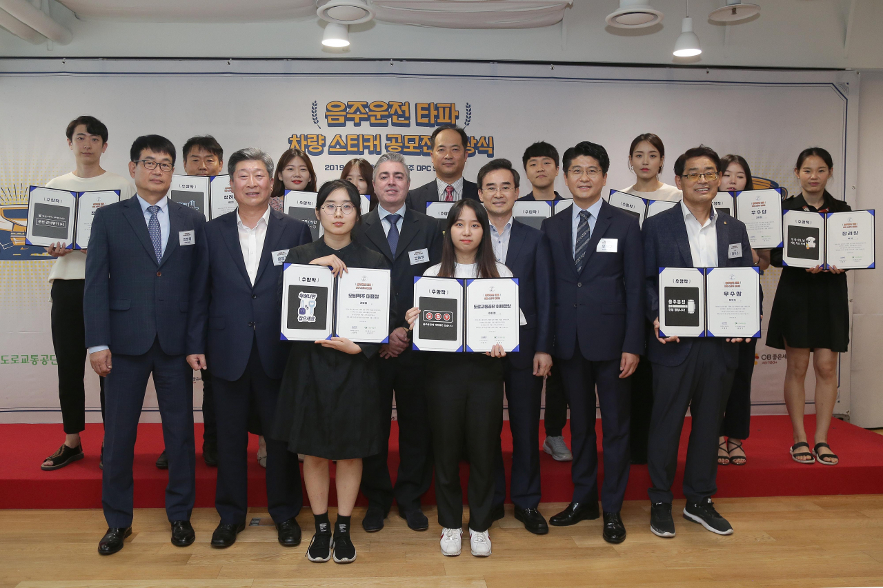 3일 서울시 강남구 오비맥주 본사에서 열린 '음주운전 타파 차량 스티커 공모전' 시상식에서고동우 오비맥주 대표(두 번째 줄 왼쪽에서 세 번째), 도로교통공단 윤종기 이사장(두 번째 줄 왼쪽에서 두 번째)이 수상자들과 함께 기념 사진을 찍고 있다. [오비맥주 제공]