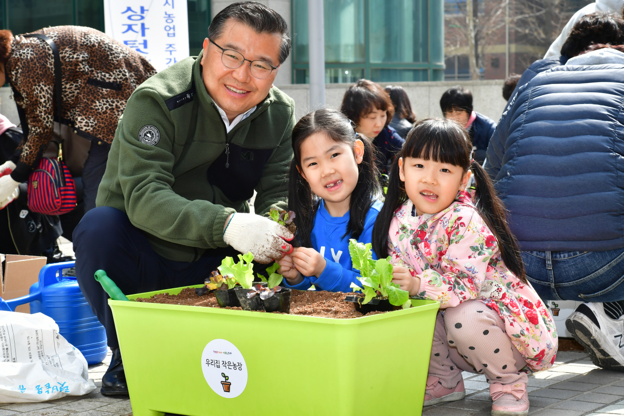 류경기 중랑구청장이 지난 4월5일 중랑구청 중앙광장에서 열린 ‘친환경 상자텃밭 나눔행사‘에서 어린이들과 상추를 심고 있다. [중랑구 제공]