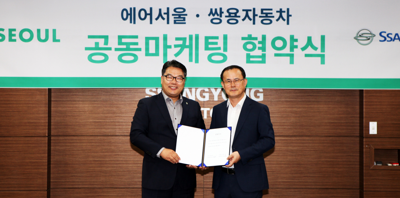 쌍용자동차 서울사무소에서 쌍용차 국내영업본부 김광호 상무(오른쪽)와 조진만 에어서울 경영본부장이 협약식을 갖고 기념촬영을 하고 있다. [쌍용차 제공]