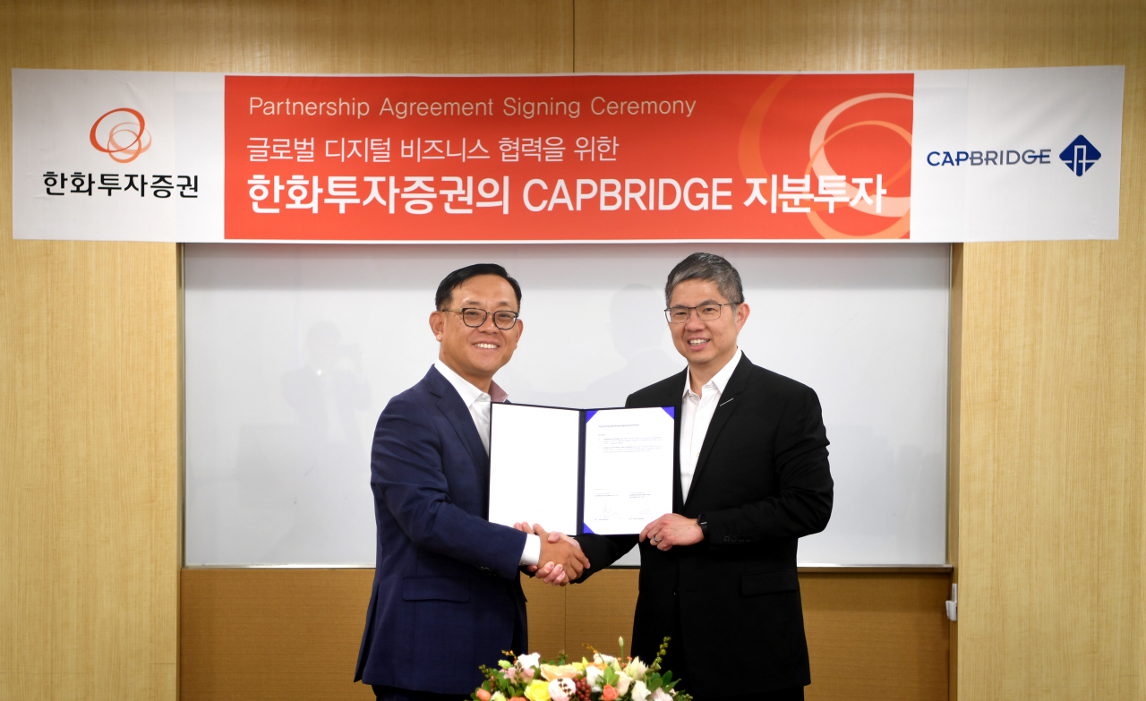 권희백 한화투자증권 대표(왼쪽)가 4일 서울 여의도 본사에서 존슨 첸 캡브릿지그룹 대표와 지분투자 협약을 맺고 기념촬영을 하고 있다.[한화투자증권]
