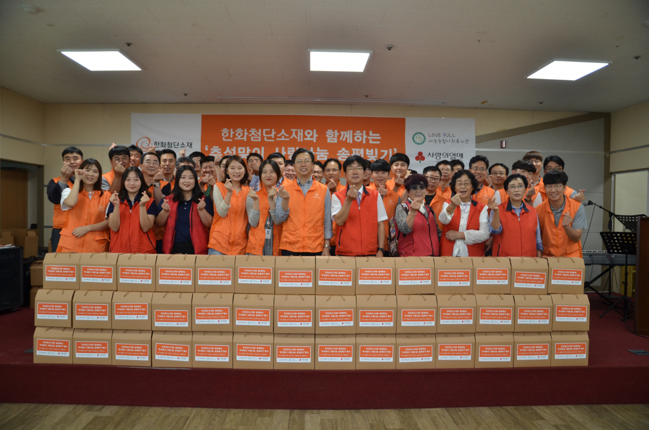 4일 이선석 한화첨단소재 대표(앞줄 가운데)와 임직원, 자원봉사자들이 송편을 만들어 포장한 후 기념촬영을 하고 있다. [한화 제공]