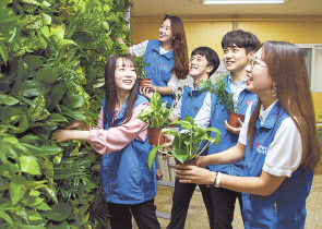현대오일뱅크 직원들이 서울 용산구 영락보릭원 건물 내 벽면에 수직 정원을 만들고 있다. [현대오일뱅크 제공]