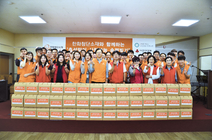 4일 이선석 한화첨단소재 대표(앞줄 가운데)와 임직원, 자원봉사자들이 송편을 만들어 포장한 후 기념촬영을 하고 있다. [한화 제공]