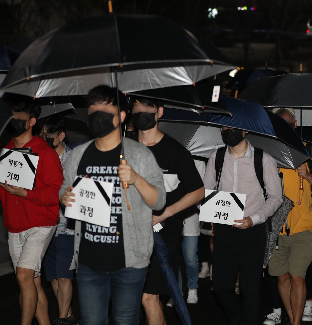6일 오후 서울 성북구 안암로 고려대학교 민주광장에서 열린 조국 법무부 장관 후보자 딸 입시특혜 의혹 진상 규명 촉구 3차 촛불집회에서 참가자들이 '기회의 평등, 과정의 공정, 결과의 정의'가 죽었다는 내용으로 검은 우산을 들고 행진하고 있다. [연합]