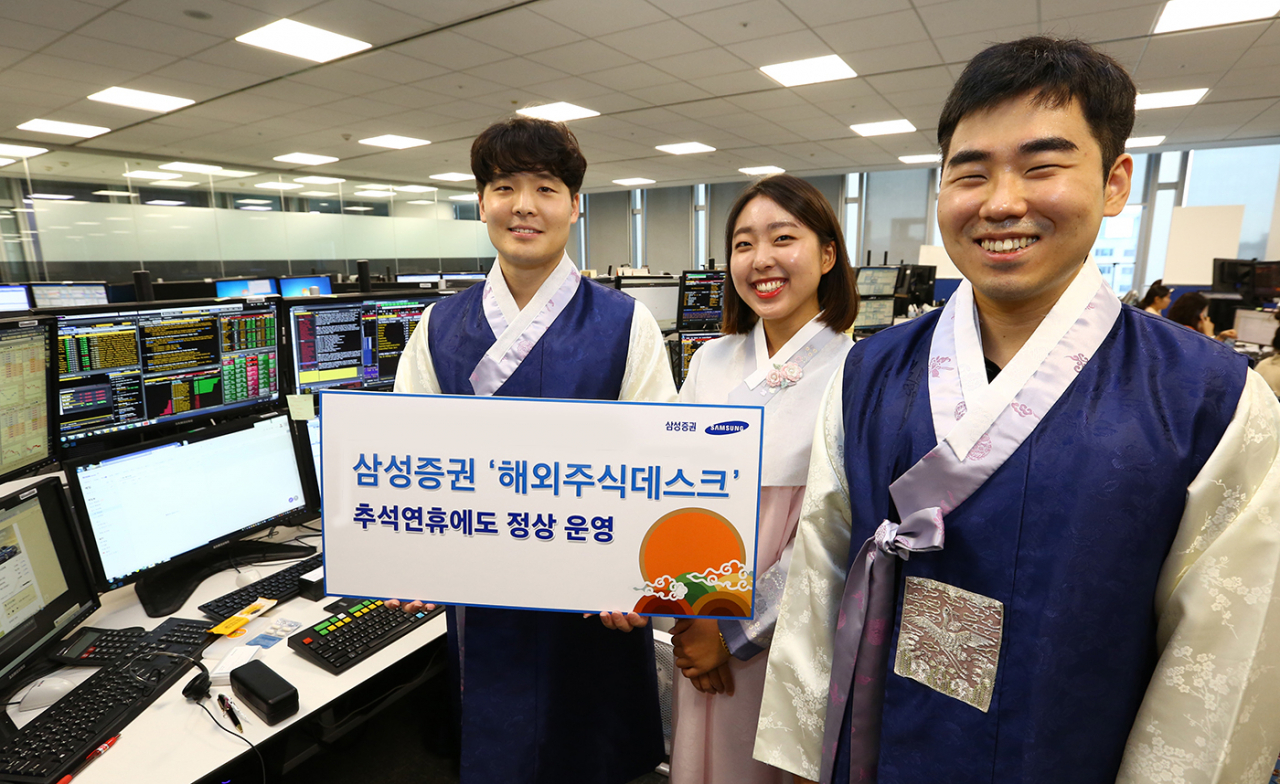 삼성증권 직원들이 추석 연휴에도 정상 운영하는 해외 주식 데스크를 소개하고 있다.[삼성증권]