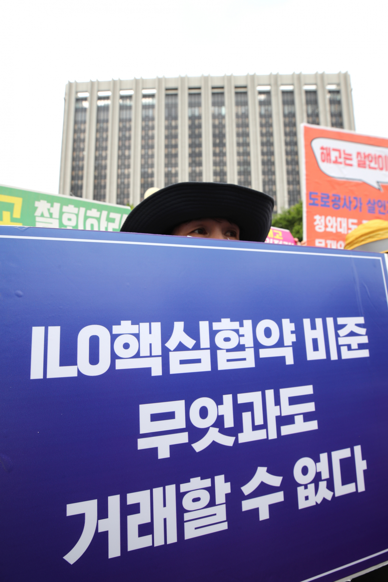 민주노총 조합원 및 ILO긴급공동행동 회원들이 지난 7월 30일 서울 종로구 정부서울청사 앞에서 열린 고용노동부 ILO 핵심협약 관련 법 규탄 기자회견에서 손피켓을 들고 있다. 고용노동부는 이날 결사의 자유에 관한 ILO 핵심협약 제87호와 제98호의 비준을 위한 '노동조합 및 노동관계조정법' 등의 주요 내용을 공개했다. [연합]