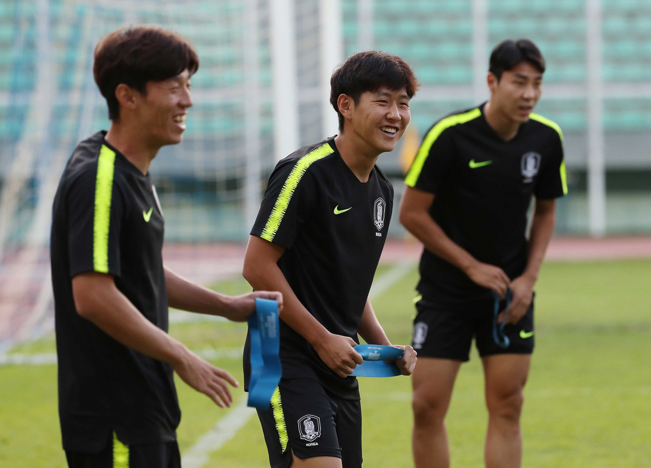 지난 9일 한국축구 국가대표팀의 이강인 선수가 투르크메니스탄과의 경기를 앞두고 몸을 푸는 도중 웃음짓고 있다. 오른쪽은 이정협, 왼쪽은 김보경. [연합]