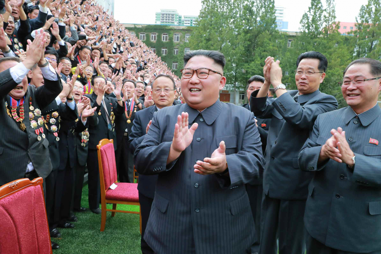 김정은 북한 국무위원장과 휘하 정부 관리들이 박수치고 있다.[연합]