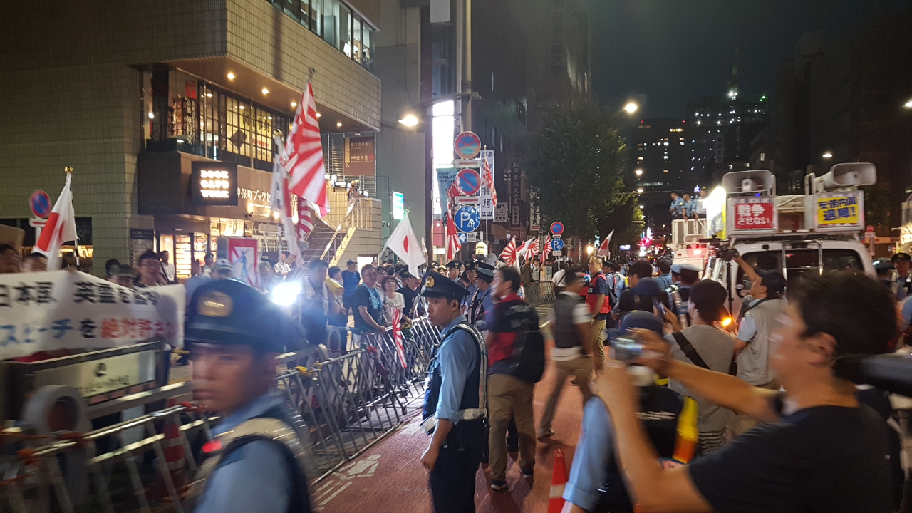 한일 시민단체들이 참여하는 '야스쿠니 반대 도쿄 촛불행동'이 8.15 광복절을 닷새 앞둔 10일 오후 도쿄 지요다구 야스쿠니신사 주변 도로에서 '야스쿠니' 반대 시위를 펼치고 있는 가운데 왼쪽으로 일장기와 욱일기를 흔들며 맞불 시위에 나선 우익 시위대가 보이고 있다. 연합뉴스