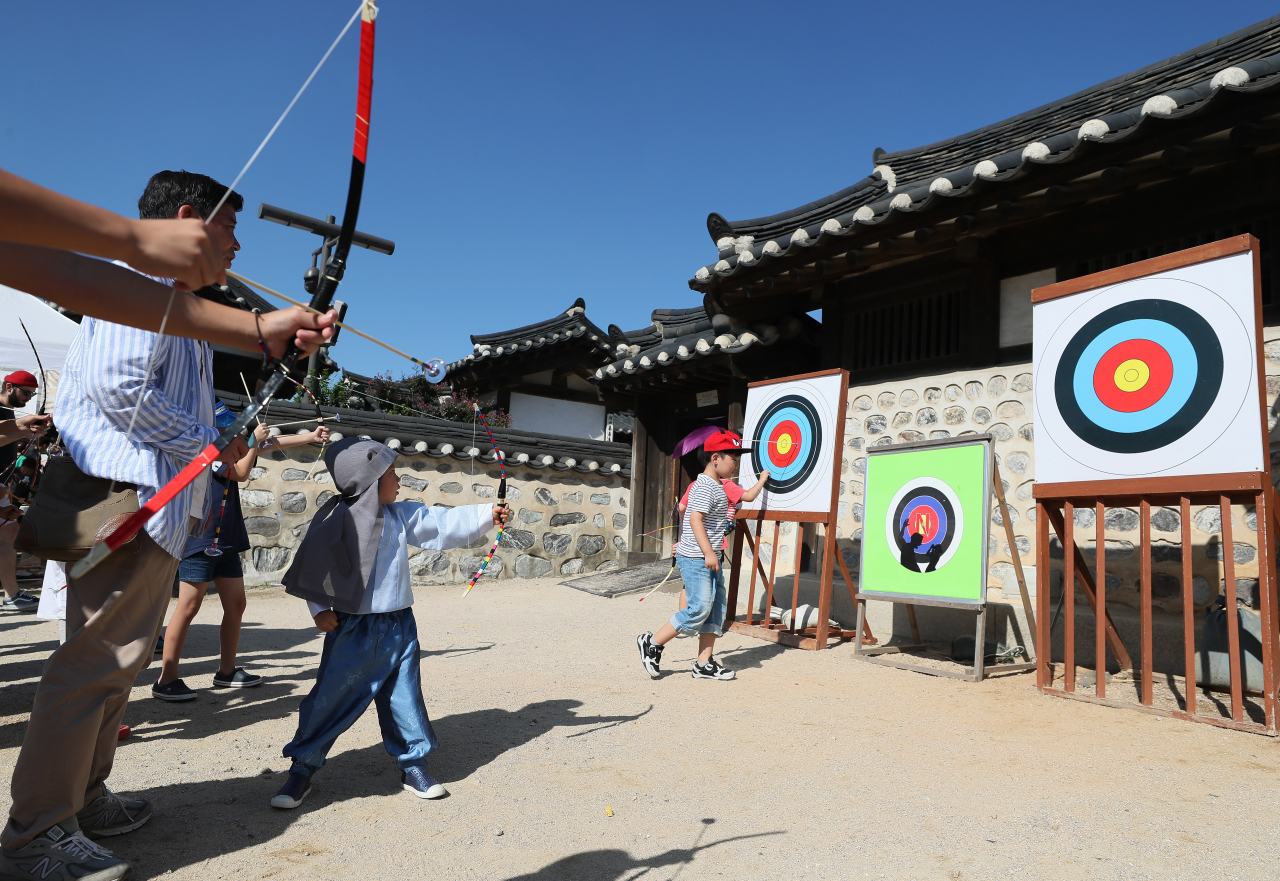 추석인 13일 오후 서울 중구 남산골 한옥마을을 찾은 시민들이 전통활쏘기를 하고 있다. [연합]