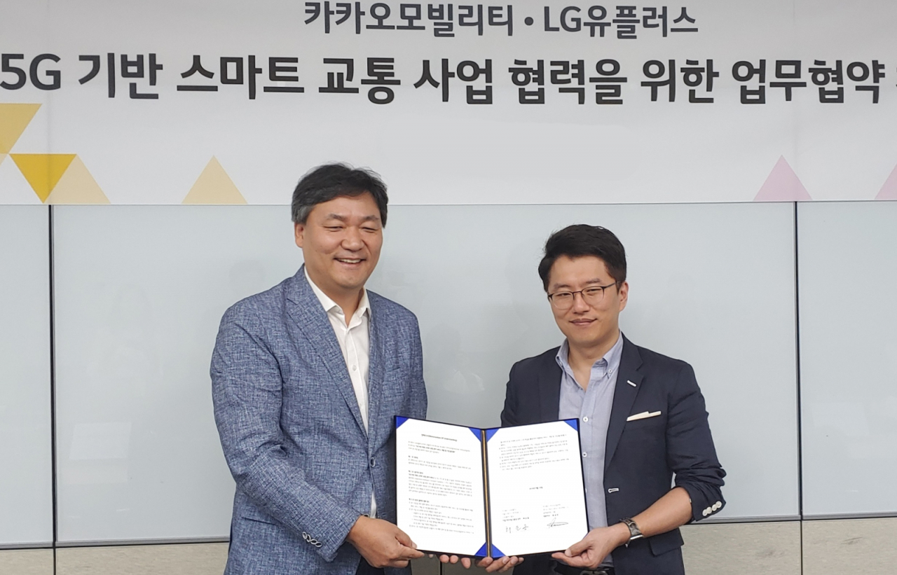 최순종 LG유플러스 기업기반사업그룹장 상무(왼쪽)와 류긍선 카카오모빌리티 공동대표가 ‘5G 기반 미래 스마트 교통 분야 서비스’ 협력을 위한 양해각서(MOU)를 맺고 기념촬영을 하고 있다. [LG유플러스, 카카오모빌리티 제공]