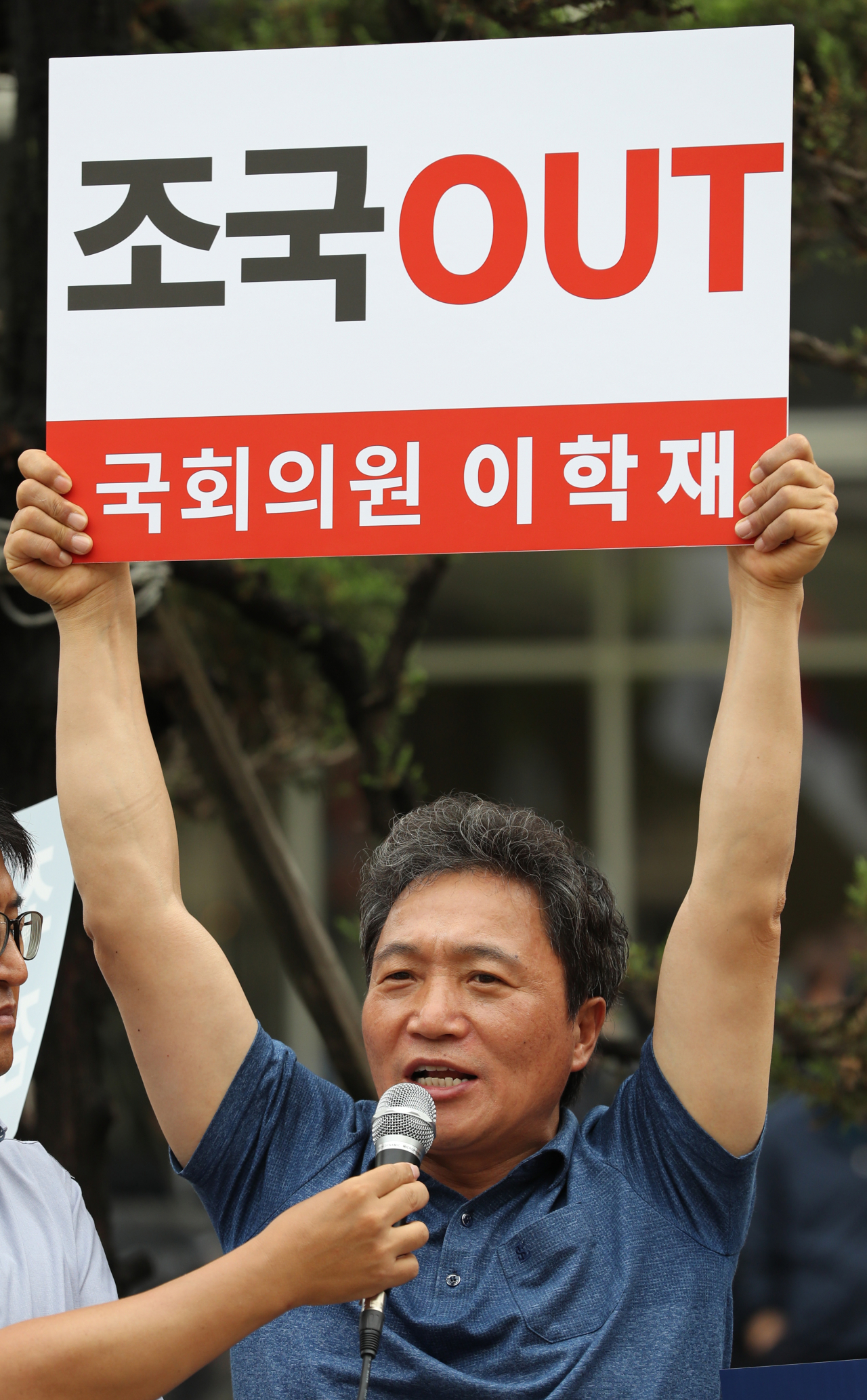 자유한국당 이학재 의원이 27일 오전 조국 법무부장관 후보자의 인사청문회 준비사무실이 차려진 서울 종로구 적선현대빌딩 앞에서 조 후보자를 규탄하는 팻말을 들고 발언하고 있다. [연합뉴스 제공]