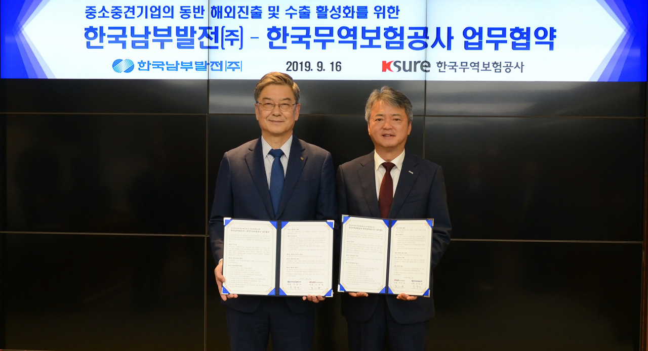 이인호(오른쪽) 한국무역보험공사 사장이 16일 부산 남부발전에서 ‘중소중견기업의 동반 해외진출 및 수출 활성화를 위한 업무협약’을 체결한 후 기념촬영을 하고 있다.［한국무역보험공사 제공］