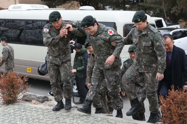 2015년 8월 서부전선 비무장지대(DMZ) 수색 작전 중 북한이 매설한 목함지뢰 도발로 두 다리를 잃은 하재헌 예비역 중사(가운데)가 올해 1월 31일 육군 1사단에서 전역식을 갖고 있다. 하 중사가 DMZ 수색 작전에 함께 참여했던 전우들과 어깨동무를 한 채 이동하고 있다. [연합]