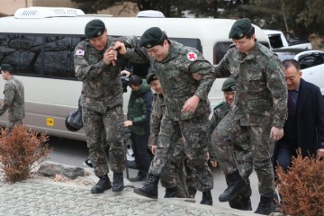 2015년 8월 서부전선 비무장지대(DMZ) 수색 작전 중 북한이 매설한 목함지뢰 도발로 두 다리를 잃은 하재헌 예비역 중사(가운데)가 올해 1월 31일 육군 1사단에서 전역식을 갖고 있다. 하 중사가 DMZ 수색 작전에 함께 참여했던 전우들과 어깨동무를 한 채 이동하고 있다. [연합]