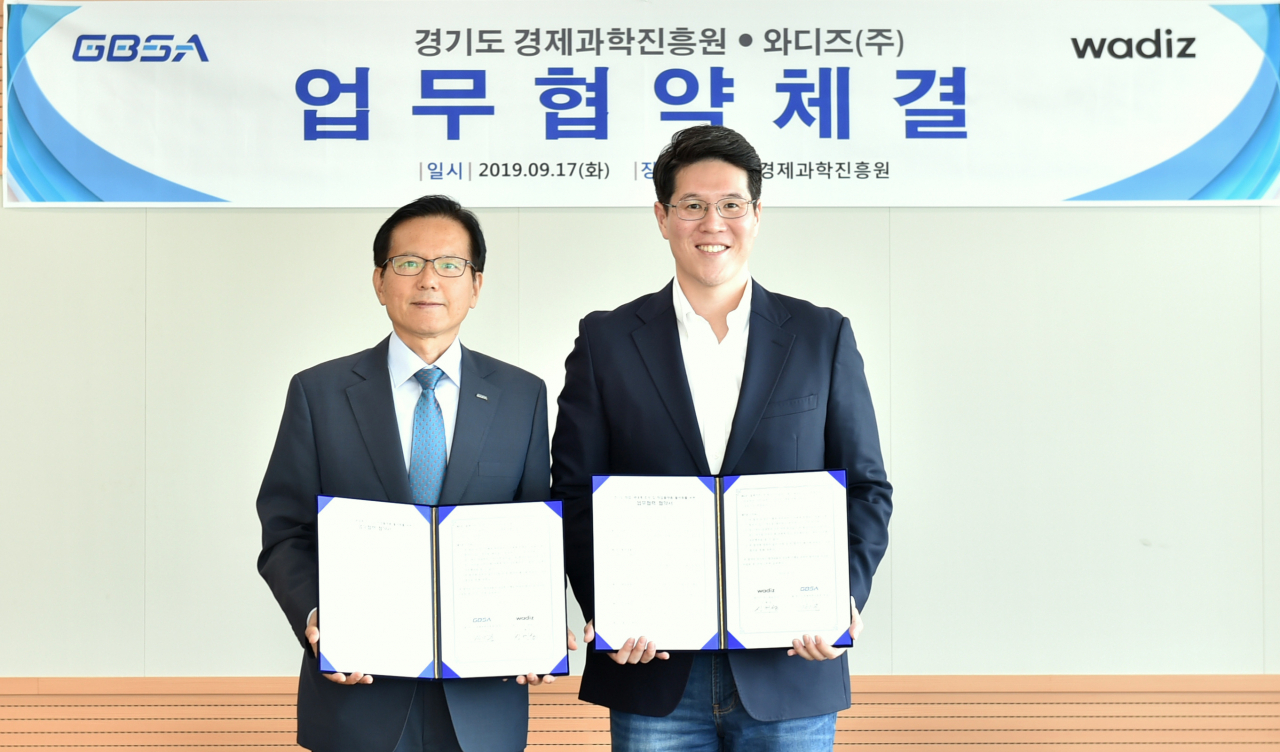 김기준 경과원장(왼쪽)과 신혜성 와디즈 대표가 협약서를 들고 기념촬영을 하고 있다.[경과원제공]