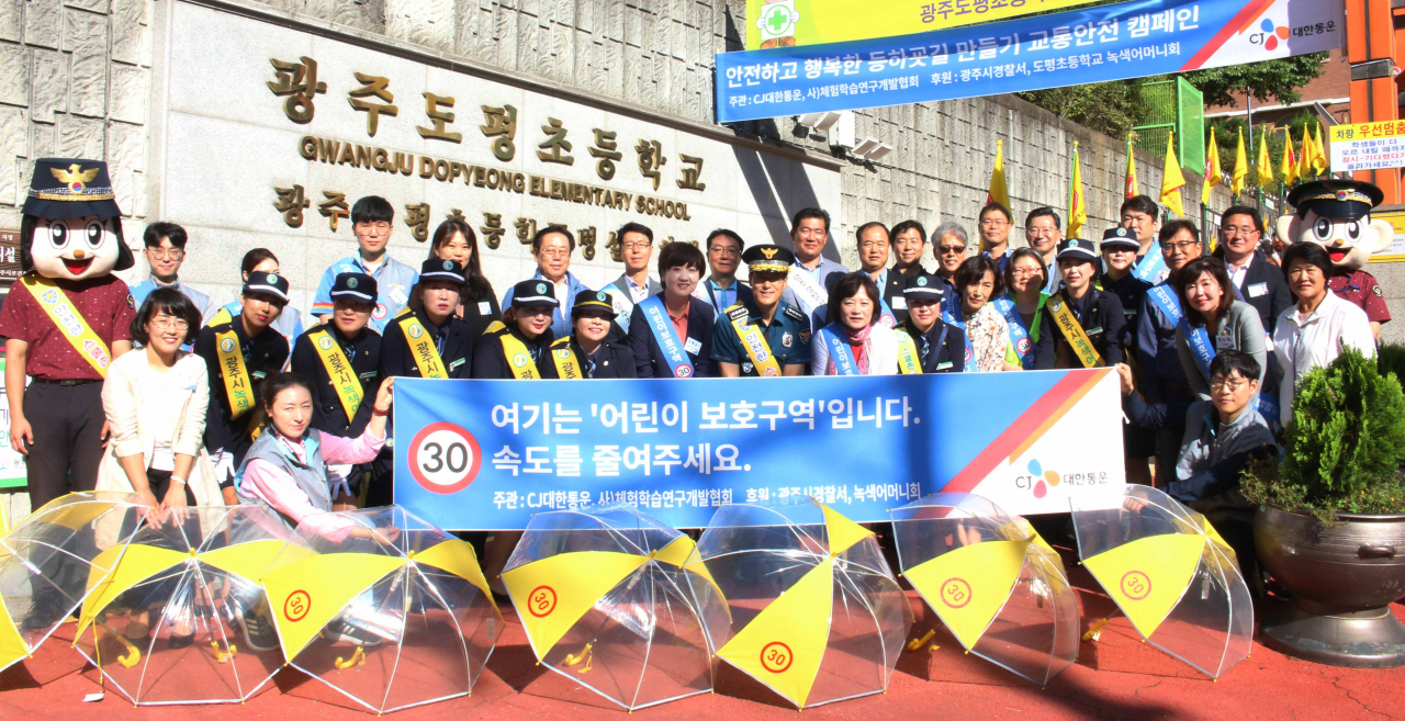 CJ대한통운은 지난 17일 경기도 광주 도평초등학교에서 등굣길 아동에게 투명 안전우산을 나눠주고 운전자를 대상으로 스쿨존 안전 운전 캠페인을 진행했다. 이날 행사에는 CJ대한통운 임직원들과 광주경찰서, 도척초등학교 녹색어머니회 등이 참여했다. [CJ대한통운 제공]