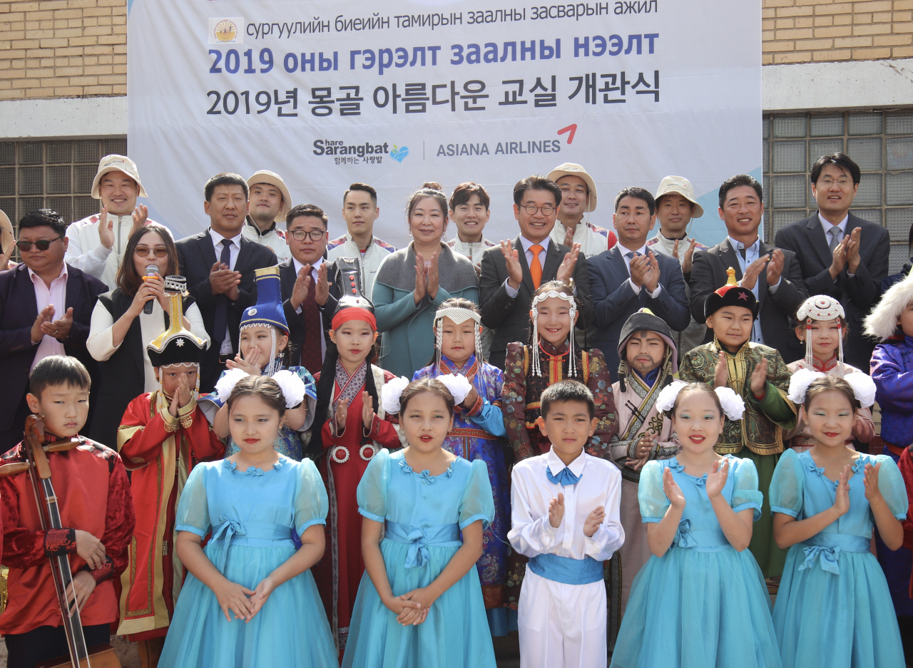 ‘아름다운 교실’ 축하 행사에 참석한 아시이나항공 조영석 상무(세번째줄 오른쪽 네번째), 83번초등학교 차장처이즈 교장(세번째줄 오른쪽 다섯번째)이 학생들과 함께 기념촬영을 하고 있다. [아시아나항공 제공]