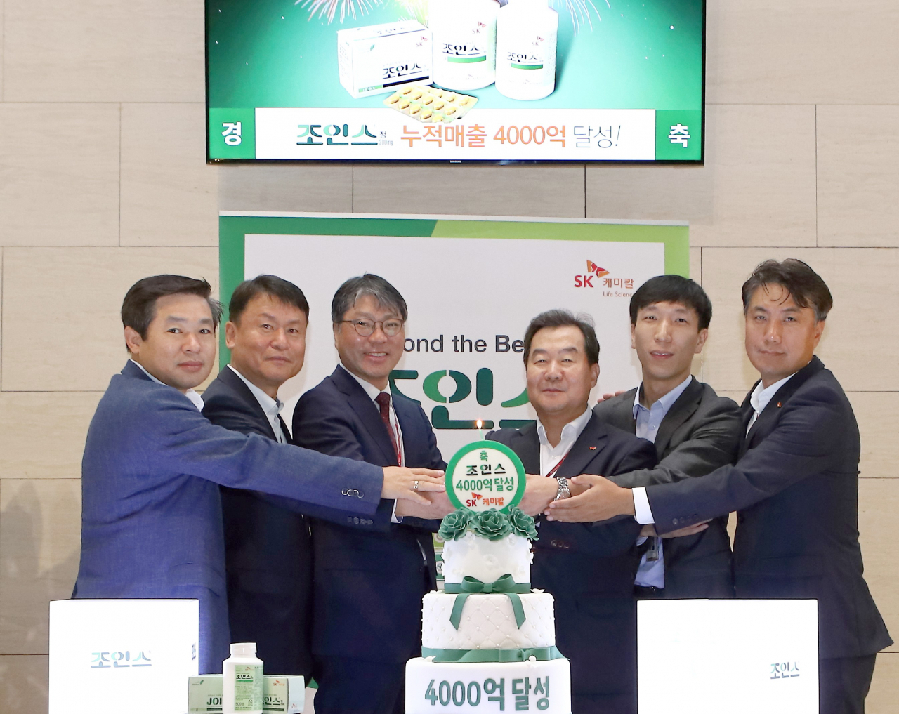 SK케미칼 전광현 사장(사진 우측 세 번째)이 구성원들과 함께 조인스정 누적매출 4000억원 돌파 기념 세레머니에서 포즈를 취하고 있다.