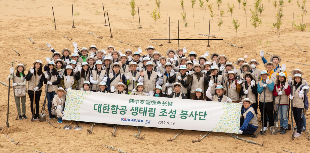 쿠부치 사막의 나무심기 봉사활동에 참가한 대한항공 직원들이 기념 촬영을 하고 있다. [대한항공 제공]